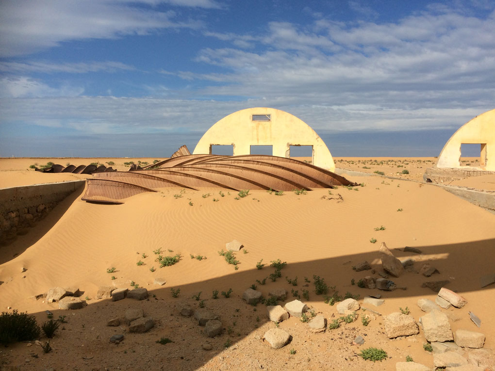 An old military base getting swallowed up by sand.